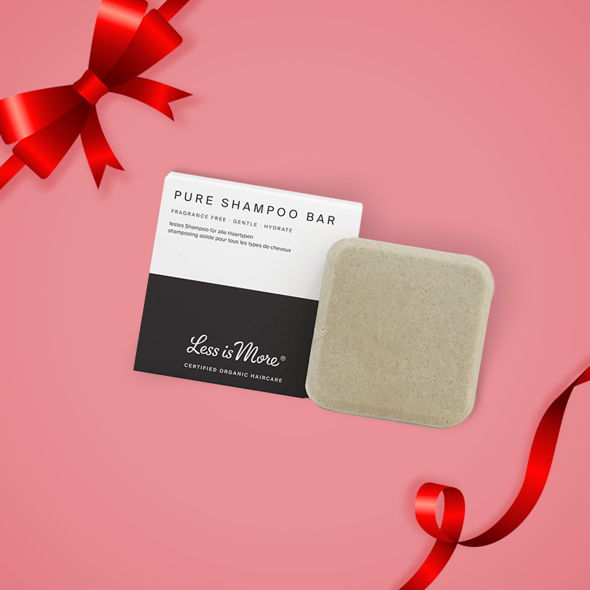 Ein Produktbild des Less is More Produktes Pure Shampoo Bar auf einem rosafarbenen Hintergrund und mit einer Schleife in der oberen linken Ecke des Bildes.